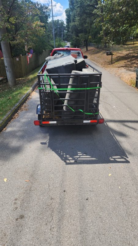 A hauling load being strapped down on the trailer